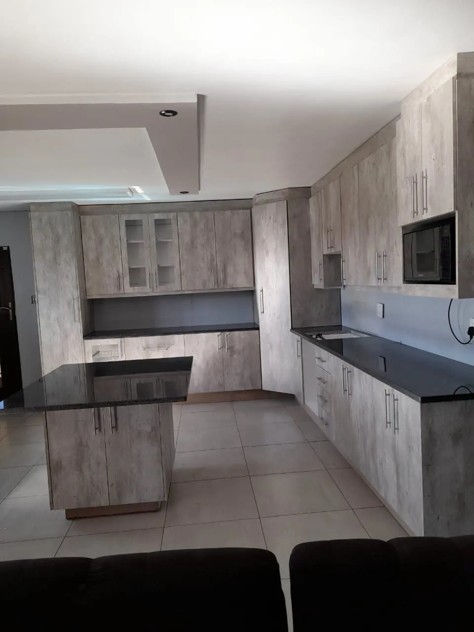 Grey kitchen with island and black worktops