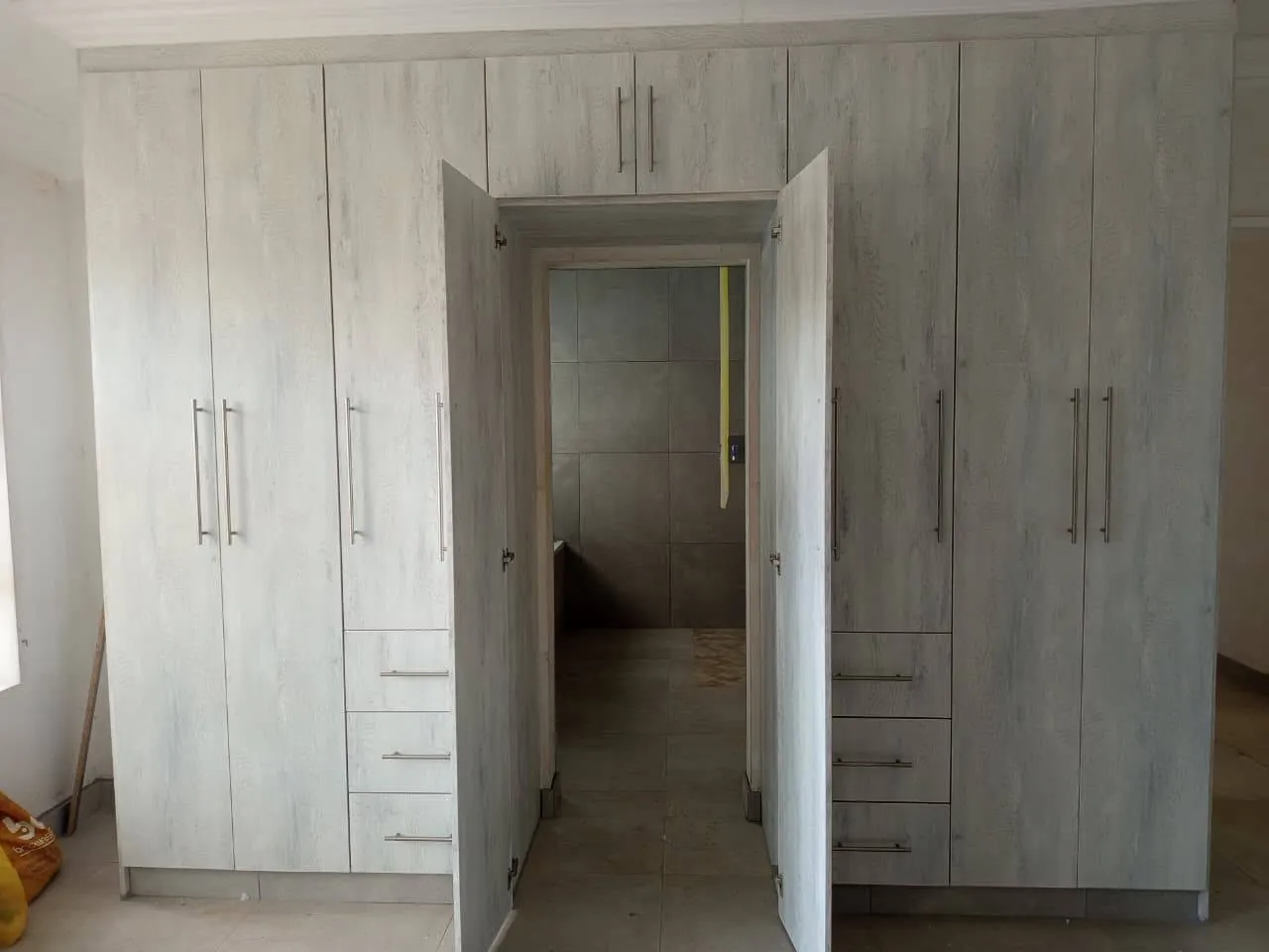 Whitewash built-in wardrobes framing a doorway