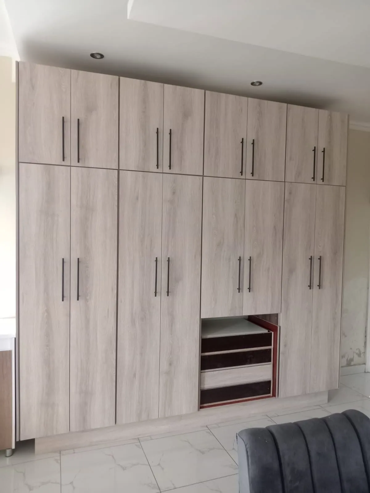 Light oak built-in wardrobe with black bar handles